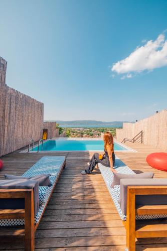 a woman sitting on a bench next to a pool at tetova in Sapanca