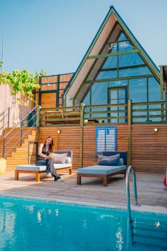 a woman sitting on a bench next to a swimming pool at tetova in Sapanca