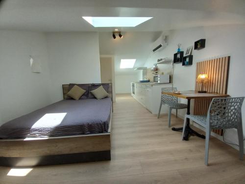 a bedroom with a bed and a table and chairs at Studio Proche Centre ville avec Place de Stationnement in Montélimar