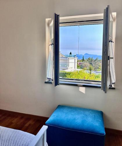 a bedroom with a blue bench in front of a window at La casetta bellevue suite in Torre del Greco