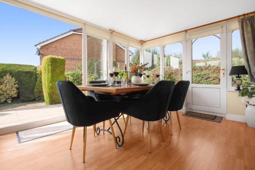 a dining room with a table and black chairs at WhiskAwayStays Toulouse Drive in Norton Junction