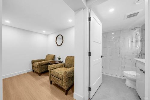 ein Badezimmer mit zwei Stühlen und einer Dusche und einer Toilette in der Unterkunft Peaceful 2 Bedroom 2 Baths Airb&b in Shaughnessy in Vancouver