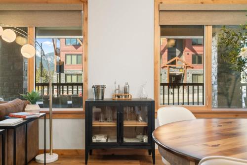 a dining room with windows and a table at Timberstone Condo by Canadian Rockies Vacation Rentals in Canmore