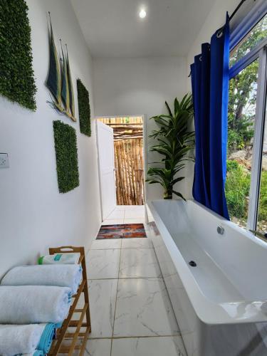 a bathroom with a large tub and a window at Beach house minutes from Ochi Rios and Ian Fleming airport in Salt Gut Pen