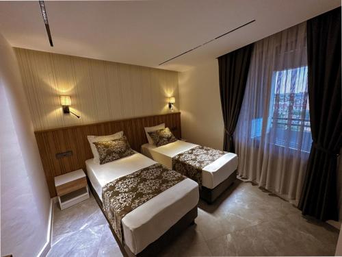 a hotel room with two beds and a window at Happy Apart Hotel in Kuşadası