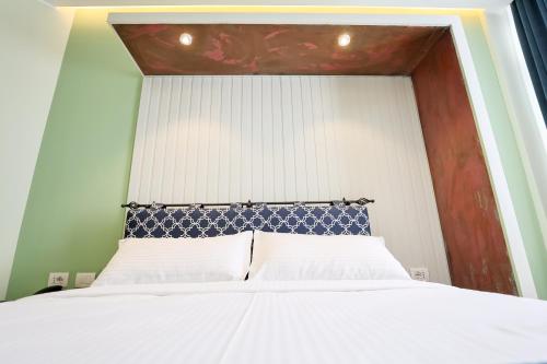 a bedroom with a white bed with a blue headboard at The MONT BOUTIQUE HOTEL in Shkodër