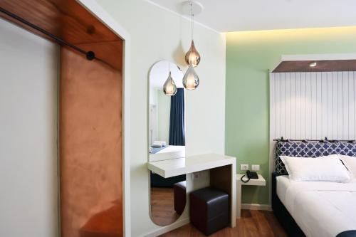 a bedroom with a bed and a sink and a mirror at The MONT BOUTIQUE HOTEL in Shkodër