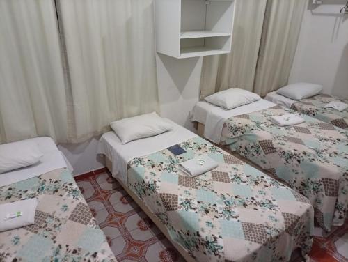Zimmer mit 3 Betten und Steppdecken in der Unterkunft Hotel Pousada Central Campo Grande in Campo Grande