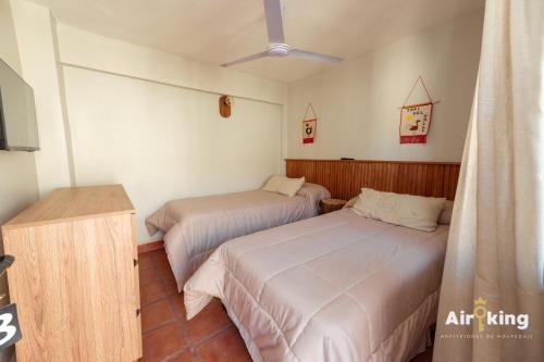 a bedroom with two beds and a tv in it at Hotel FG Tafi in Tafí del Valle