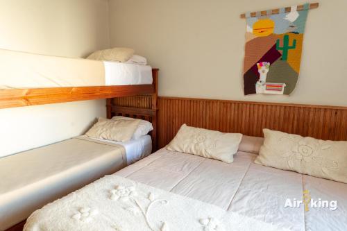 a bedroom with two bunk beds and a painting at Hotel FG Tafi in Tafí del Valle