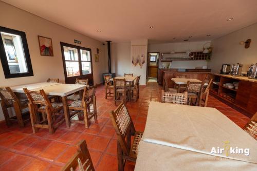 a restaurant with tables and chairs and a kitchen at Hotel FG Tafi in Tafí del Valle