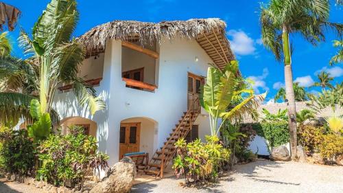 a house on the beach with palm trees at Guest-Room 2 Palmeras with a pool in Las Galeras in Las Galeras