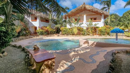 a house with a swimming pool in front of a house at Guest-Room 2 Palmeras with a pool in Las Galeras in Las Galeras