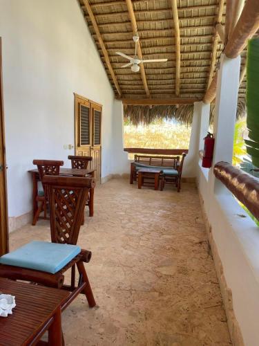 a room with tables and chairs and a ceiling at Guest-Room 2 Palmeras with a pool in Las Galeras in Las Galeras