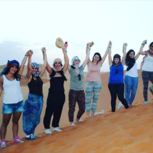 a group of women running on the beach at Merzouga traditional Camp in Merzouga