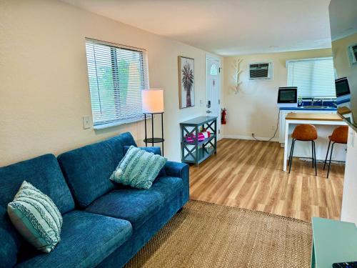 a living room with a blue couch and a kitchen at Sun-Drenched 1BR Apt - 5min walk to Beach in Clearwater Beach