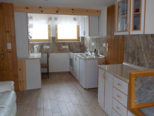 eine Küche mit weißen Schränken und einer Spüle in der Unterkunft Apartment Ivanka Cvetek in Bohinj