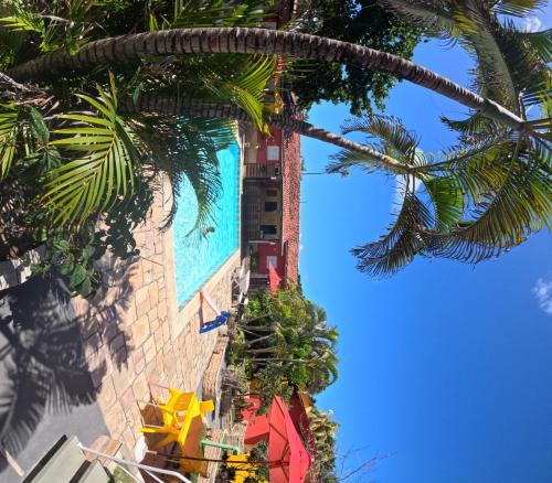 a view of a building with palm trees at Pousada Flor de Merepe - Porto de Galinhas in Porto De Galinhas