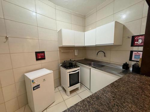 a small kitchen with a stove and a sink at Pousada Flor de Merepe - Porto de Galinhas in Porto De Galinhas