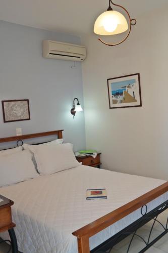a bedroom with a bed with a book on it at Maroussa Studios in Agia Anna Naxos