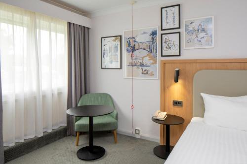 a hotel room with a bed and a chair at Holiday Inn Cambridge by IHG in Cambridge