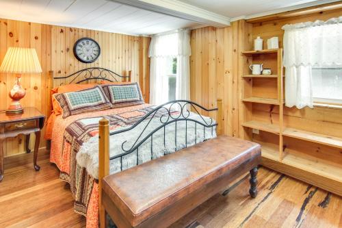 a bedroom with a bed with a bench and a clock at Close to Snowtubing! Hot Tub Hideaway in Lake Lure in Lake Lure