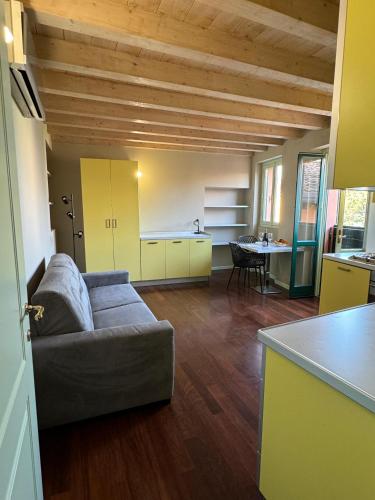 a large living room with a couch and a kitchen at Magic apartment with view on Garda lake in the center of Desenzano in Desenzano del Garda