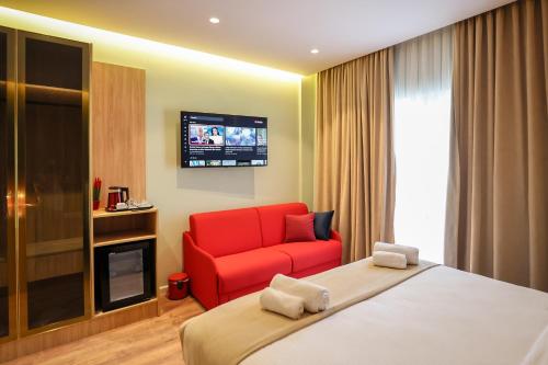 a hotel room with a bed and a red chair at The MONT BOUTIQUE HOTEL in Shkodër