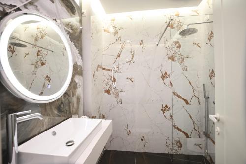 a bathroom with a white sink and a mirror at The MONT BOUTIQUE HOTEL in Shkodër