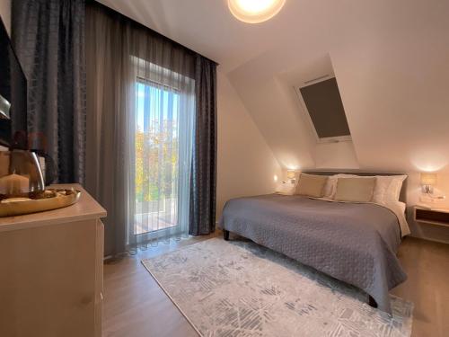 a bedroom with a bed and a large window at Weekend House Alsóörs in Alsóörs