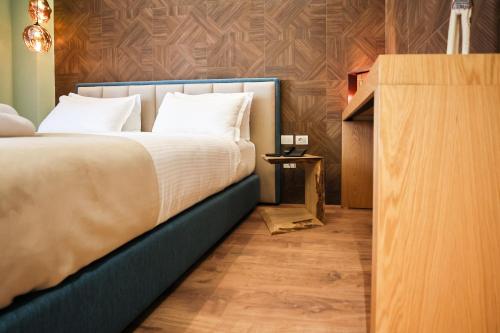 a bedroom with a large bed and a wooden floor at The MONT BOUTIQUE HOTEL in Shkodër