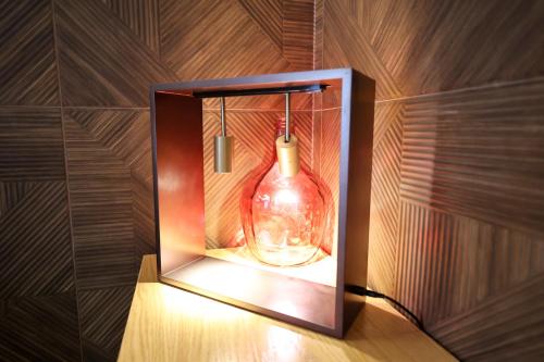 a glass bottle in a box on a wall at The MONT BOUTIQUE HOTEL in Shkodër