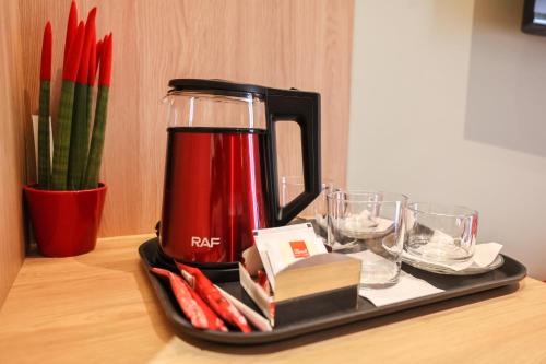 a tray with a red coffee maker on a table at The MONT BOUTIQUE HOTEL in Shkodër