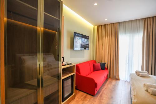 a living room with a red couch and a tv at The MONT BOUTIQUE HOTEL in Shkodër
