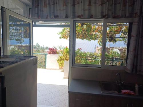 a kitchen with two windows and a view of a balcony at Relax House in Lukovë