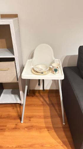 a white table with dishes on it next to a couch at Casinha no coração do Oeste in Cadaval