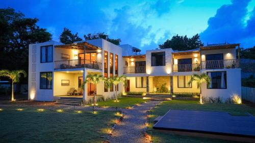a large white house with a yard at night at Villavida Boutique Hotel - La Playita in Las Galeras