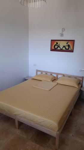 a large bed sitting in a room with a wall at Casa IRI - plaja Corbu in Corbu