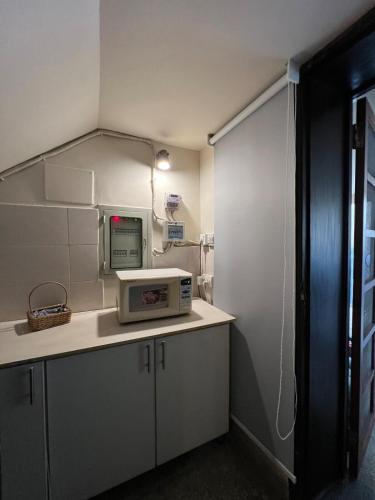 a kitchen with a microwave sitting on a counter at The Vaulted Retreat! F7 in Islamabad