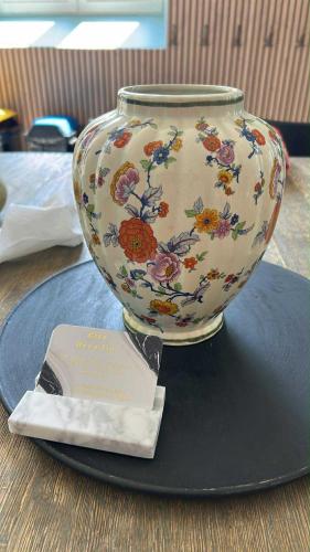 a large vase sitting on a plate with a card at Hôtel Déco'lia-Soirée étape in Ballon