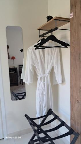 a white shirt hanging on a wall with a mirror at La Petite Sologne in Chaumont-sur-Tharonne