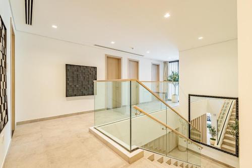 a staircase in a house with glass railing at Luxurious Villa on Saadiyat for Large Groups and Families in Abu Dhabi