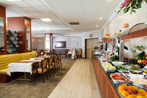 a restaurant with tables and chairs and a buffet at Spilos Hotel in Manisa