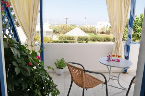 a balcony with a table and chairs and a view at Maroussa Studios in Agia Anna Naxos