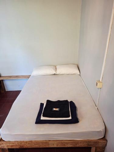 a bed in a small room with a hat on it at Mediterraneo Youth Hostel in Asuncion