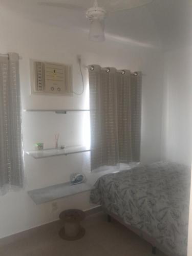a bedroom with a bed and a sink and windows at Descanso e aconchego massaguacu in Caraguatatuba