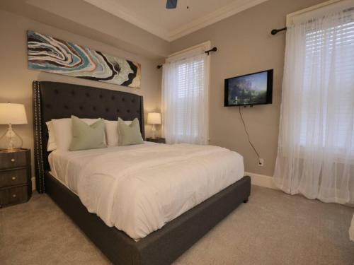 Un dormitorio con una cama grande con sábanas blancas. en Elegant French-garden Courtyard Retreat In Dallas, en Dallas