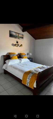 a bedroom with a large bed with yellow pillows at restaurant japonais Tokogine chambre d hote in Listrac-Médoc