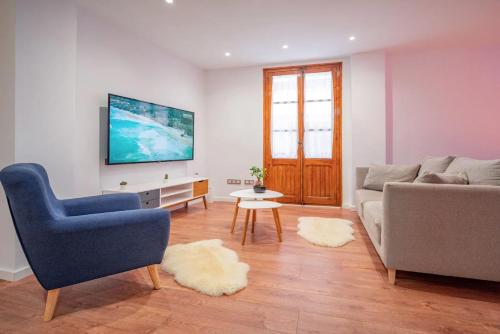 ein Wohnzimmer mit Sofa und Fernseher in der Unterkunft El Pilar Luxury Suites By VALENCIAFLATS EU in Valencia