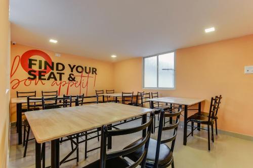 a restaurant with tables and chairs in a room at Hotel O Vittala Comforts in Bengaluru